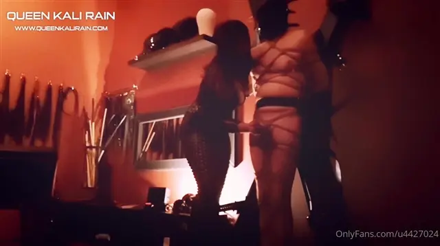 Poster: Queen Kali Rain - Dungeon Red chastity, clamp his nipples